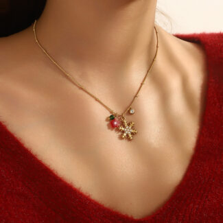 delicate gold christmas necklace with festive charms on neck